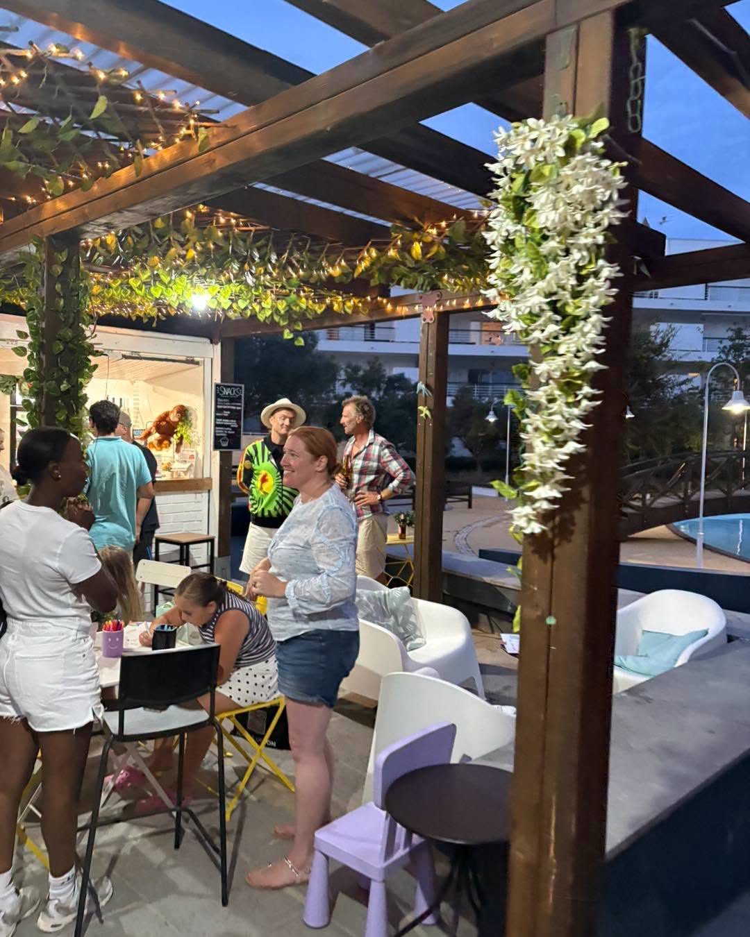 The garden at dusk with string lights on and people talking