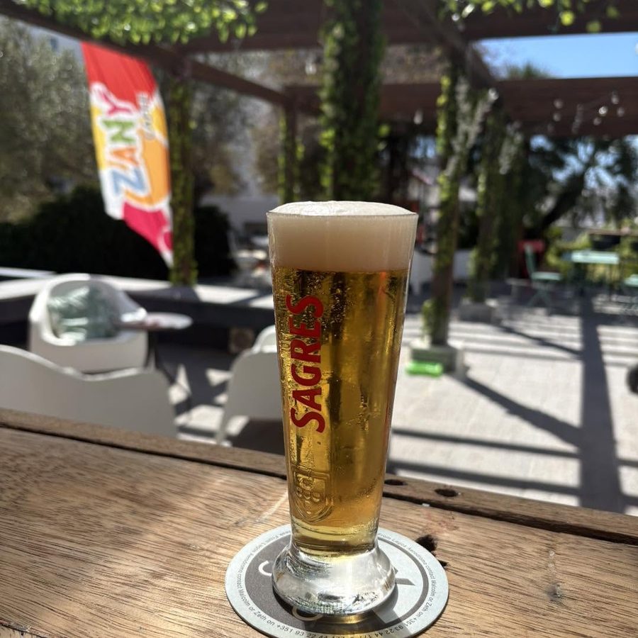 A cold Sagres on a wooden table in the sun